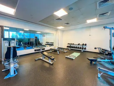 a gym with several treadmills and a large mirror at Dubai Marina Elegant 1 BR on the Canal in Dubai