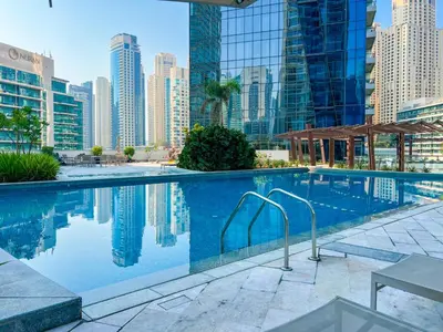 a swimming pool in a city with tall buildings at Dubai Marina Elegant 1 BR on the Canal in Dubai