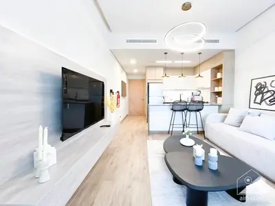 a living room with a couch and a table at Rokane G25 Studio Modern Comfort with City Views in Dubai