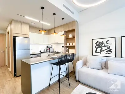 a kitchen and a living room with a couch and a table at Rokane G25 Studio Modern Comfort with City Views in Dubai