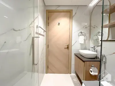 a bathroom with a shower and a sink and a mirror at Rokane G25 Studio Modern Comfort with City Views in Dubai