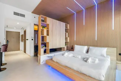 a bedroom with a large white bed and wooden shelves at Exclusive Apt 4 Pex with Burj Khalifa View in Dubai