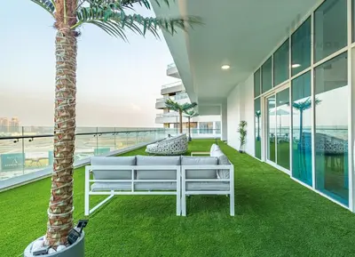 a living room with a palm tree and a white couch at Modern 2BR Glowing Palm Trees Near Downtown in Dubai