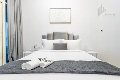 a bedroom with a bed with two towels on it at Modern 2BR Glowing Palm Trees Near Downtown in Dubai
