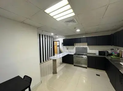 a kitchen with black and white cabinets and a sink at Partition Room with window Near Mashreq Metro in Dubai