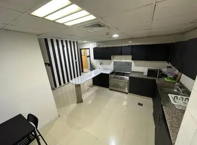 a kitchen with black and white cabinets and a stove at Gateway Partition Room in Barsha Mashreq Metro in Dubai