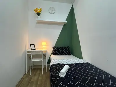 a bedroom with a bed with a green and white canopy at Cityscape Room In Tecom Near ICM Metro in Dubai