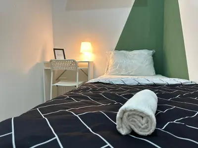 a bedroom with a bed with a towel on it at Cityscape Room In Tecom Near ICM Metro in Dubai