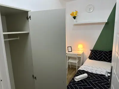 a small bedroom with a bed with a green canopy at Cityscape Room In Tecom Near ICM Metro in Dubai