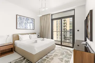 a white bedroom with a bed and a large window at Silkhaus Beachside Spacious 2BDR in Marina Vista in Dubai