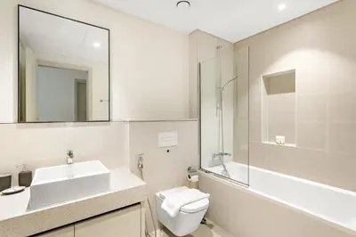 a bathroom with a sink and a toilet and a mirror at Silkhaus Beachside Spacious 2BDR in Marina Vista in Dubai