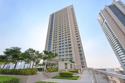 a tall building with trees in front of it at Silkhaus Beachside Spacious 2BDR in Marina Vista in Dubai