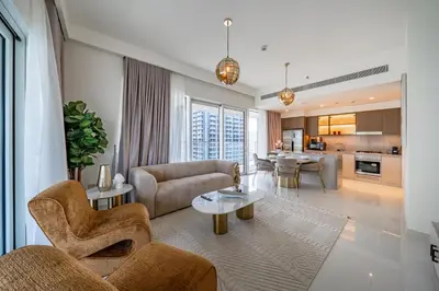 a living room with a couch and a table at Homes Beyond I Stylish 2BR Beachfront Bliss in Dubai