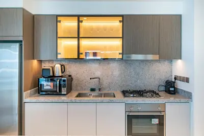 a kitchen with a sink and a stove top oven at Homes Beyond I Stylish 2BR Beachfront Bliss in Dubai