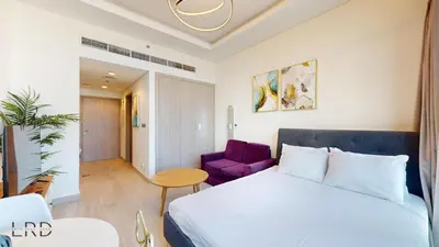 a bedroom with a bed and a purple chair at Stylish Studio Retreat in Azizi Farhad in Dubai