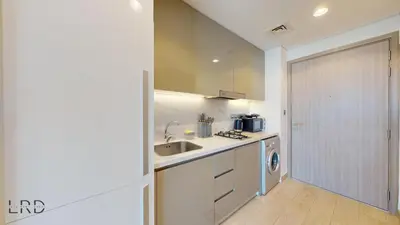 a white kitchen with a sink and a dishwasher at Stylish Studio Retreat in Azizi Farhad in Dubai