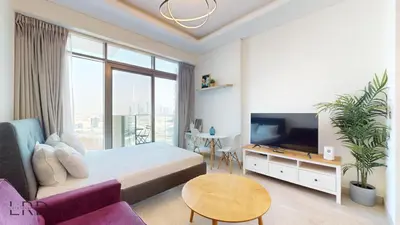 a bedroom with a bed and a tv and a couch at Stylish Studio Retreat in Azizi Farhad in Dubai