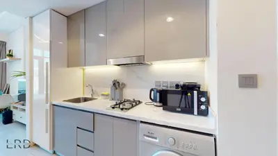 a kitchen with white cabinets and a black microwave at Stylish Studio Retreat in Azizi Farhad in Dubai