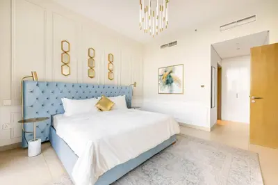 a bedroom with a blue bed and a chandelier at Elegant 4BR Apartment with Burj Khalifa and Fountain Views Connected to Dubai Mall in Dubai