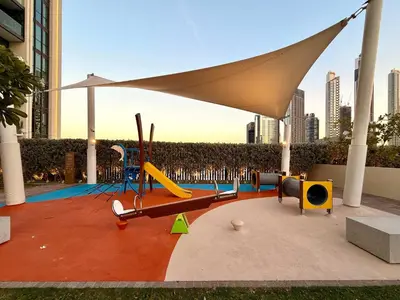 a playground with chairs and an umbrella in a city at Elegant 4BR Apartment with Burj Khalifa and Fountain Views Connected to Dubai Mall in Dubai