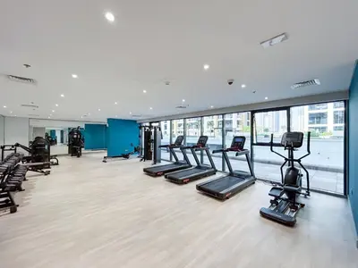 a gym with treadmills and elliptical machines at Chic & Beautiful Home in the Heart of Meydan in Dubai