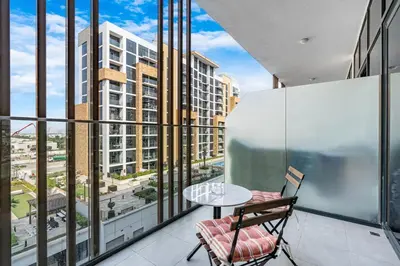 a balcony with a table and chairs and a view of a city at Chic & Beautiful Home in the Heart of Meydan in Dubai