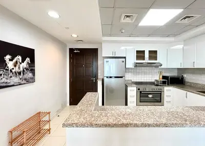 a kitchen with a refrigerator and a counter top at Homes 2 Retreat - Luxury & Spacious 1BR with Balcony in Business Bay in Dubai
