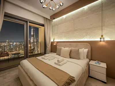 a bedroom with a large bed with a large window at Royal Vista - Luxury 4BR Apartment at Downtown Views II - Downtown in Dubai