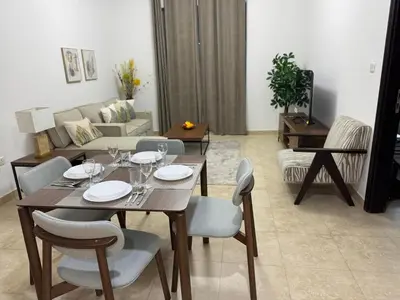 a living room with a wooden table and chairs at Preatoni Tower - JLT by Golden Casa in Dubai