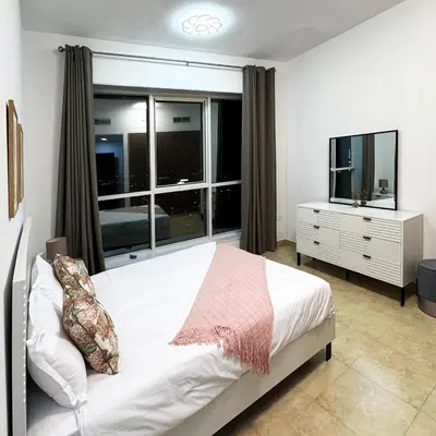 a bedroom with a bed and a large window at Preatoni Tower - JLT by Golden Casa in Dubai