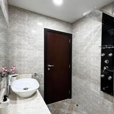 a bathroom with a toilet and a brown door at Preatoni Tower - JLT by Golden Casa in Dubai