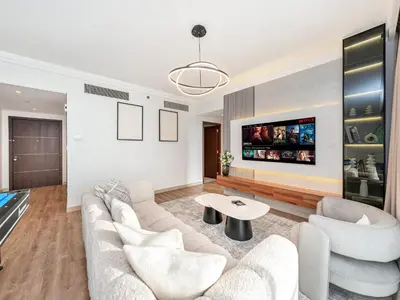 a living room with white furniture and a flat screen tv at Royal Vista - Luxury 4BR Apartment at Boulevard Point - Downtown in Dubai