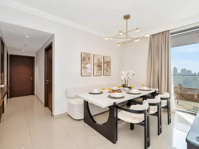 a kitchen and dining room with a table and chairs at Royal Vista - Luxury 4BR Apartment at Boulevard Point - Downtown in Dubai