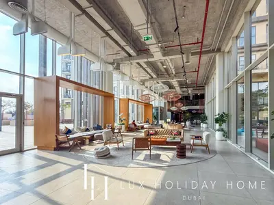 a lobby with tables and chairs in a building at LUX The Collective Dubai Hills Suite in Dubai