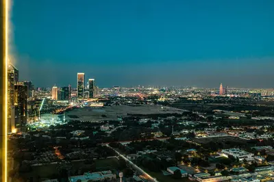 a view of a city at night with at Downtown Chic 2 Bedroom Apartment I Dubai Mall Access I Views of Burj Khalifa from Pool I Free Parking, Gym, Pool & Wi-Fi I by Meerak in Dubai