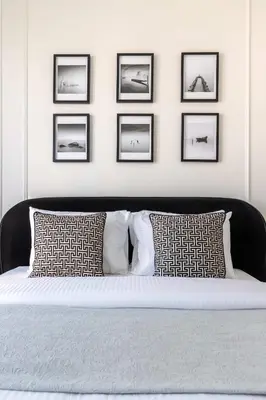 a bedroom with a bed with four pictures on the wall at Frank Porter - Grande Signature Residences in Dubai