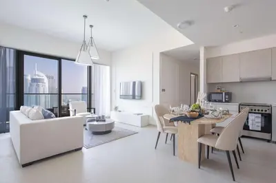 a kitchen and living room with a table and chairs at Frank Porter - Grande Signature Residences in Dubai