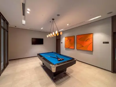 a pool table in a room with paintings on the wall at Frank Porter - Grande Signature Residences in Dubai