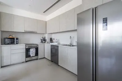 a kitchen with a stainless steel refrigerator and a sink at Frank Porter - Grande Signature Residences in Dubai