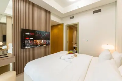 a bedroom with a large white bed and a tv at KeyRock Luxury Apartment at Aykon Tower with Views in Dubai
