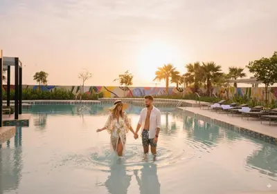 a man and woman walking in the water at a resort at Keyrock Living - Luxury Stay in Business Bay in Dubai