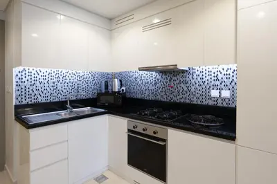 a white kitchen with a sink and a stove at Keyrock Living - Luxury Stay in Business Bay in Dubai