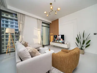 a living room with a white couch and a tv at Gorgeous Beachfront 2 Bed Retreat in Marina Vista in Dubai