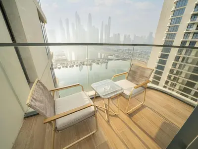 a balcony with two chairs and a table on a building at Gorgeous Beachfront 2 Bed Retreat in Marina Vista in Dubai