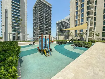 a playground in a city with people playing on it at Gorgeous Beachfront 2 Bed Retreat in Marina Vista in Dubai