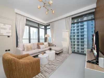 a living room with a couch and a tv at Gorgeous Beachfront 2 Bed Retreat in Marina Vista in Dubai