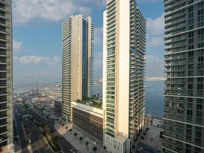 two tall buildings in a city next to the water at Gorgeous Beachfront 2 Bed Retreat in Marina Vista in Dubai