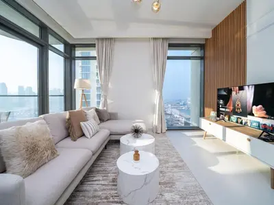 a living room with a couch and a tv at Gorgeous Beachfront 2 Bed Retreat in Marina Vista in Dubai