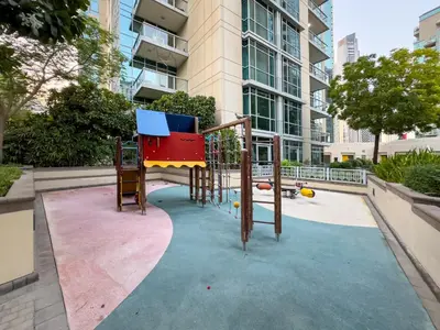 a playground in front of a tall building at WonderfulStay at The Residences - Best Burj Khalifa & Fountain View - Brand New Luxury Apartments in Dubai