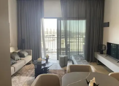 a living room with a couch and a tv at Brand New Designer 1-Bedroom Apartment With Free Parking in Dubai